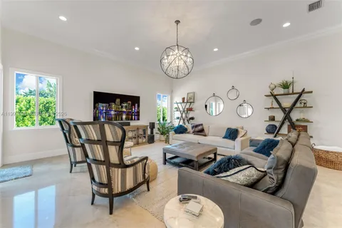 a living room with furniture chandelier and a window
