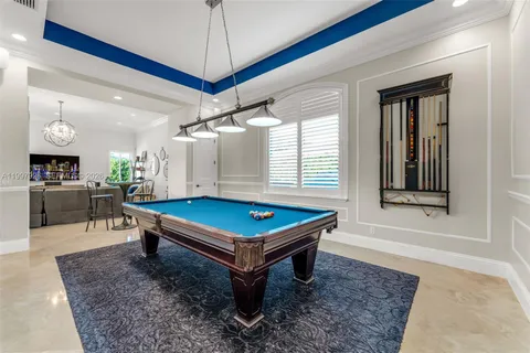 a room with pool table and windows