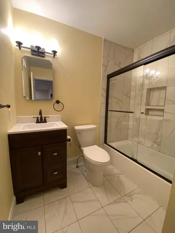 a bathroom with a sink vanity mirror and toilet