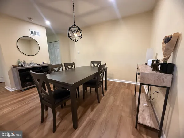 a view of a dining room with furniture a chandelier and wooden floor