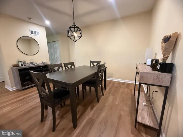 a view of a dining room with furniture a chandelier and wooden floor