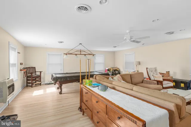 a spacious bedroom with a bed a couch and dresser with wooden floor