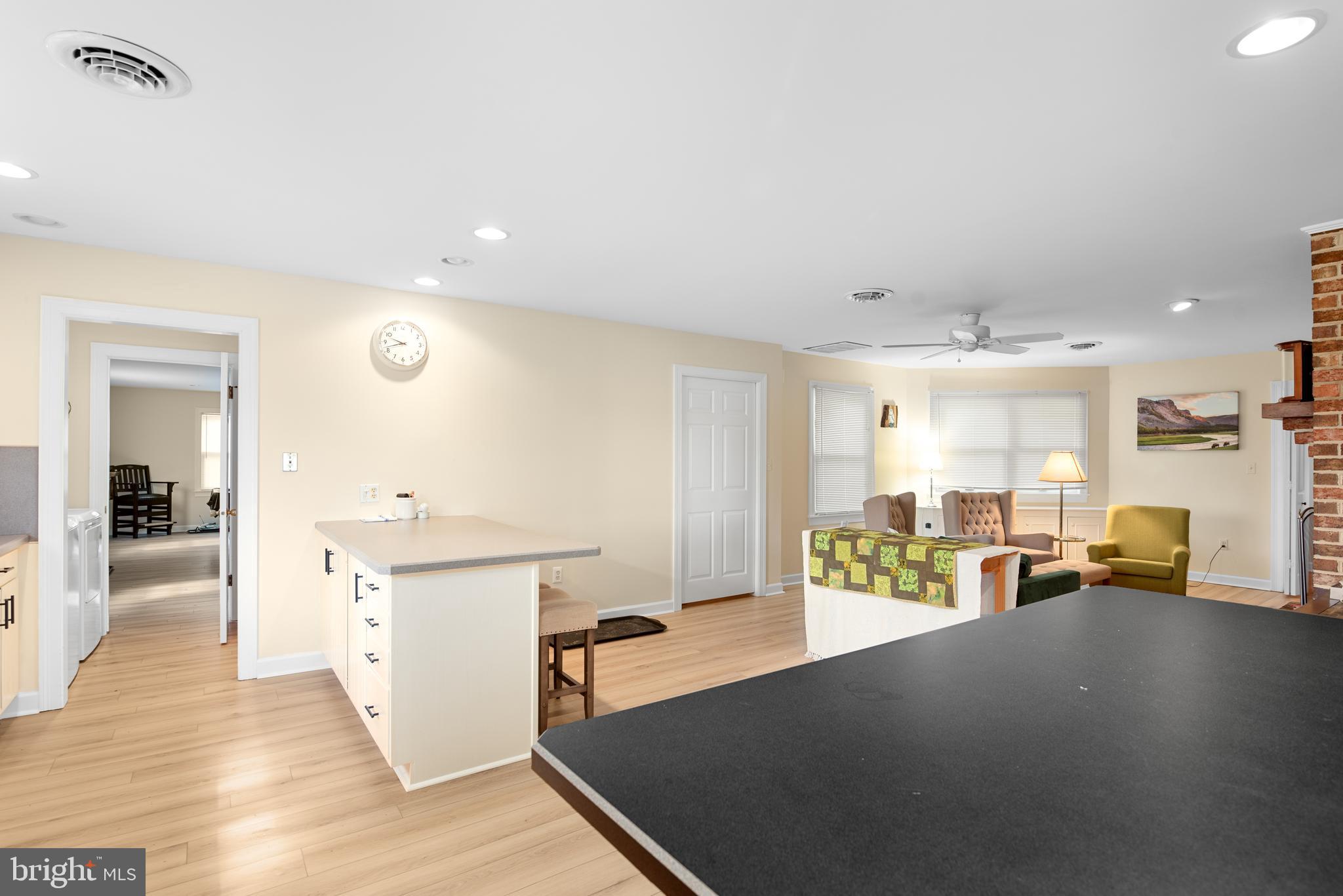 6379 Cedar Cove Road Royal Oak, MD 21662 - Photo 8 of 32 a living room with kitchen island furniture and a wooden floor