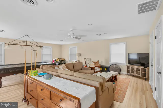 a living room with furniture a flat screen tv and a floor to ceiling window