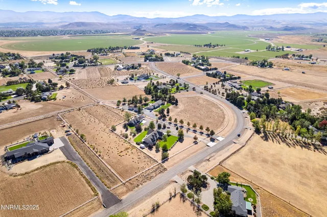 an aerial view of ocean and residential houses with outdoor space