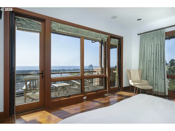 a bedroom with a large bed and large windows
