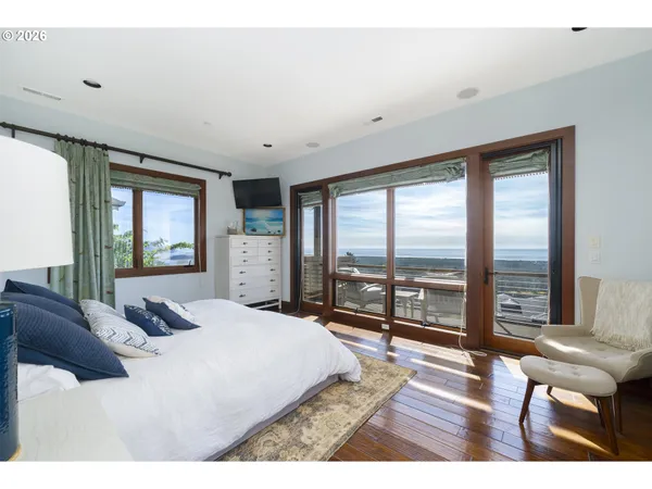 a bedroom with a bed and a flat tv screen on dresser