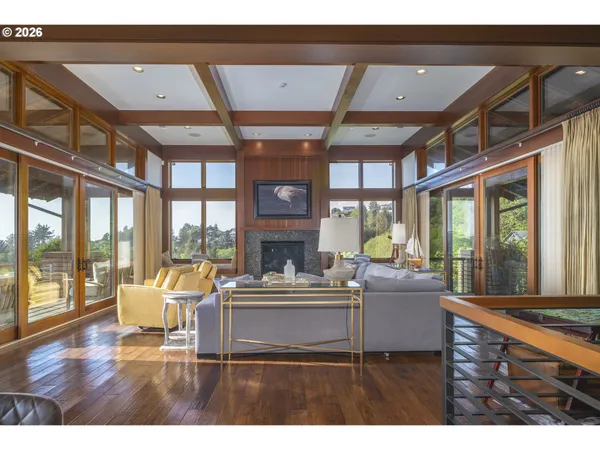 a living room with furniture a fireplace and a floor to ceiling window