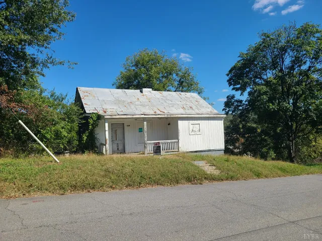 a view of a house with a yard and large tree