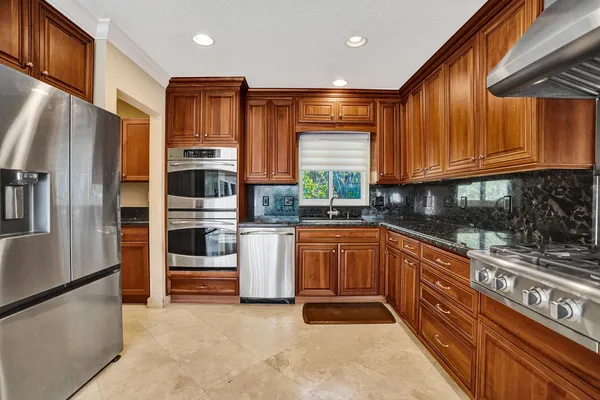 a kitchen with stainless steel appliances granite countertop a refrigerator sink and stove