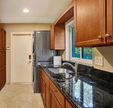 a kitchen with granite countertop a sink and a refrigerator