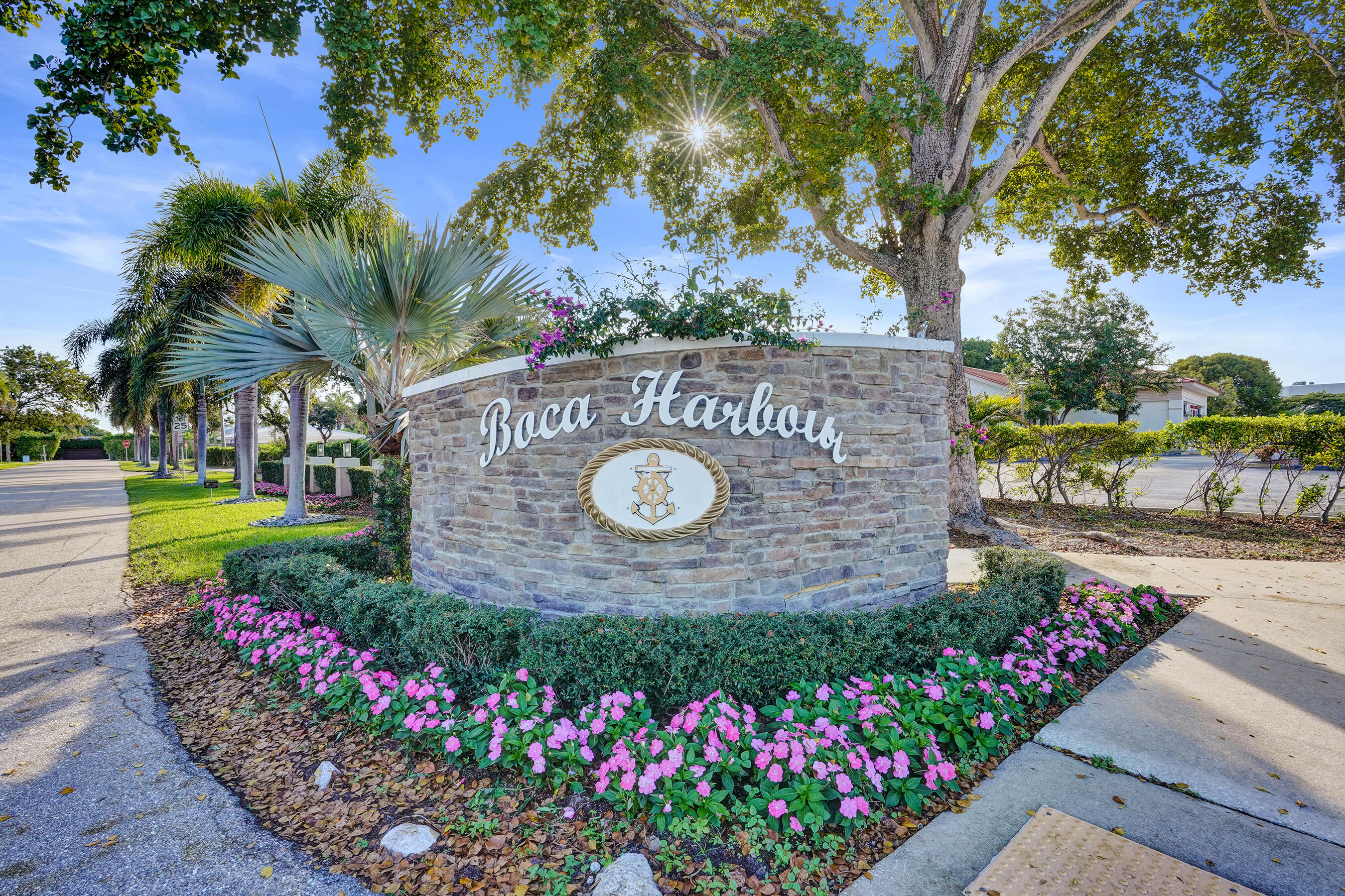 7050 Northeast 7th Avenue Boca Raton, FL 33487 - Photo 3 of 25 a view of a sign board with flower plants