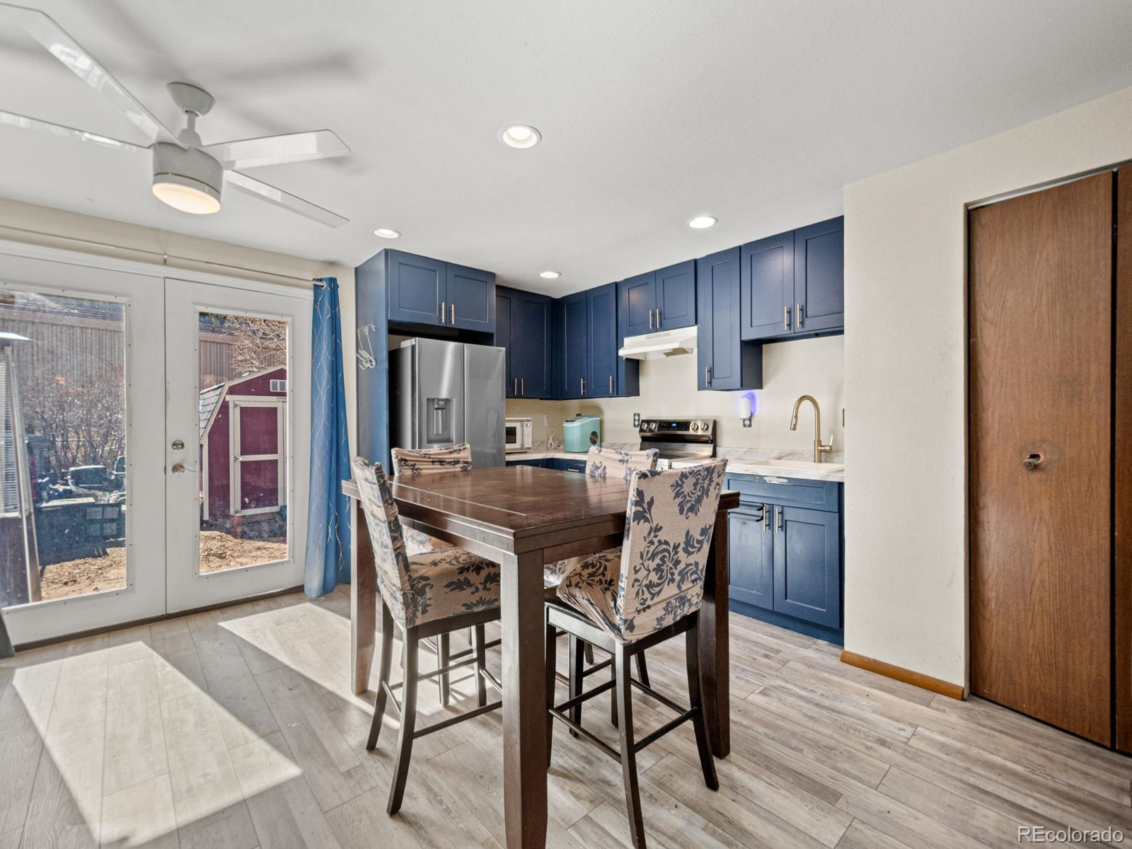 3301 Riverside Drive Idaho Springs, CO 80452 - Photo 8 of 35 a kitchen with stainless steel appliances kitchen island granite countertop a refrigerator a stove a sink dishwasher and a dining table with wooden floor