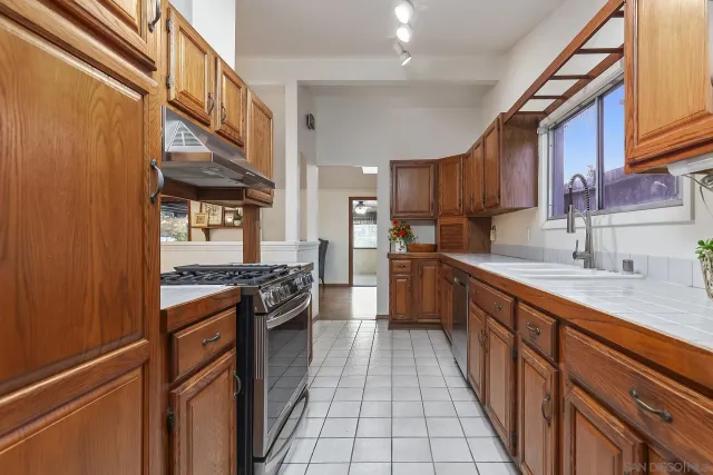 a kitchen with stainless steel appliances granite countertop a stove a sink dishwasher and a refrigerator