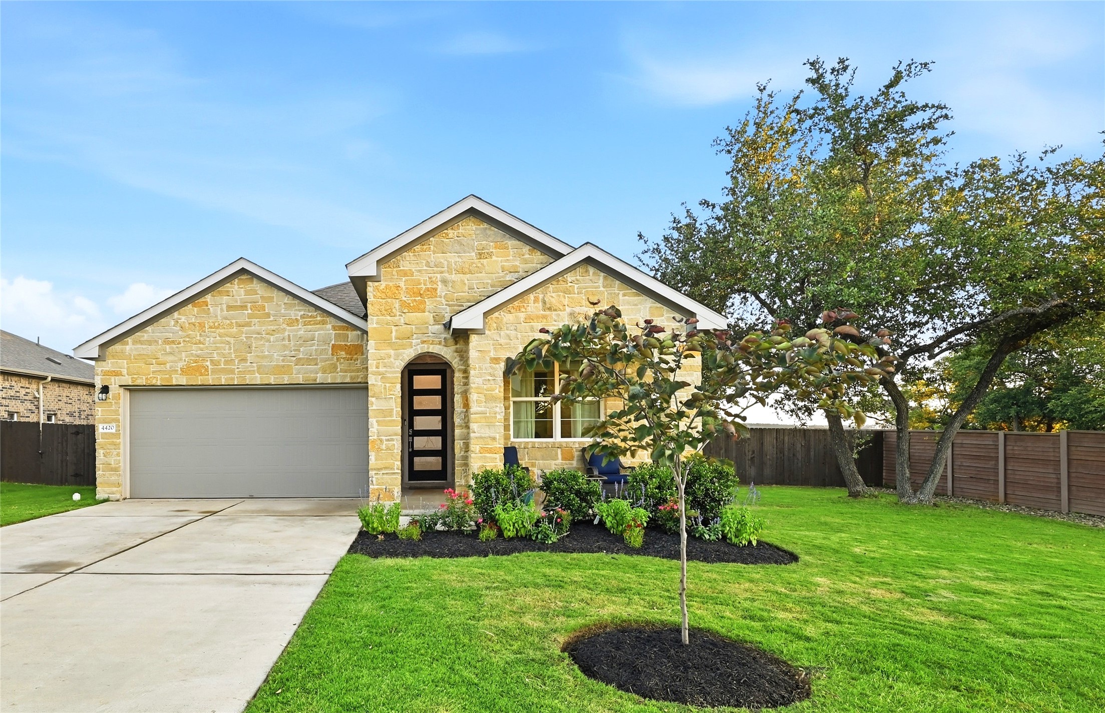 4420 Ingram Road Georgetown, TX 78628 - Photo 5 of 40 A well-kept lawn and vibrant landscaping frame this inviting stone-clad residence.