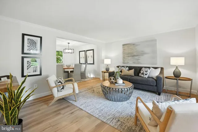 a living room with furniture wooden floor and a lamp