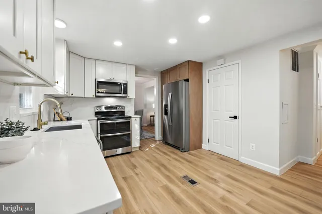 a kitchen with granite countertop a refrigerator stove and sink