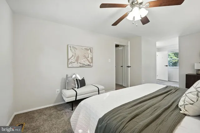 a bedroom with a bed and a lamp on dresser