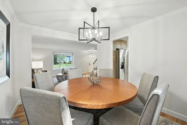 a dining room with furniture a chandelier and wooden floor