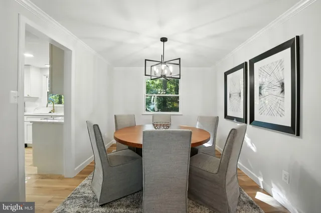 a dining room with furniture a chandelier and wooden floor