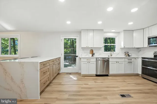 a kitchen with a stove a sink a microwave a counter top space and cabinets