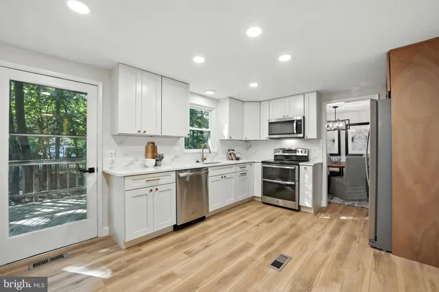 a kitchen with white cabinets and stainless steel appliances
