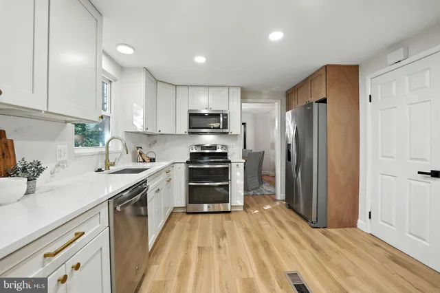 a kitchen with stainless steel appliances a refrigerator sink and stove