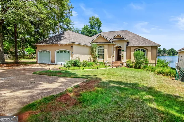 a front view of a house with a yard and potted plants