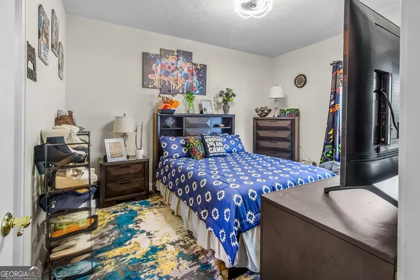 a bedroom with a bed and a painting on the wall