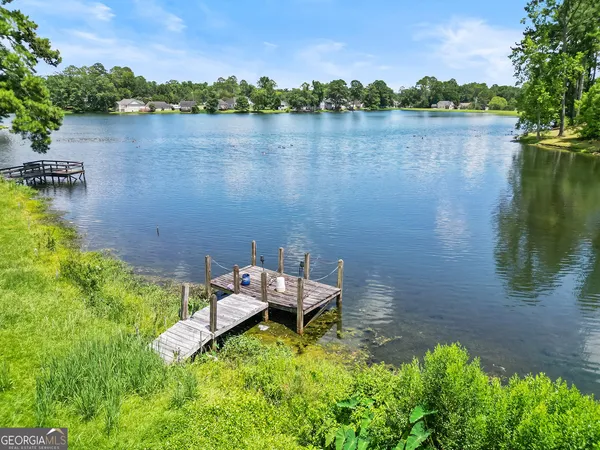 a backyard of a house with lots of green space and lake view