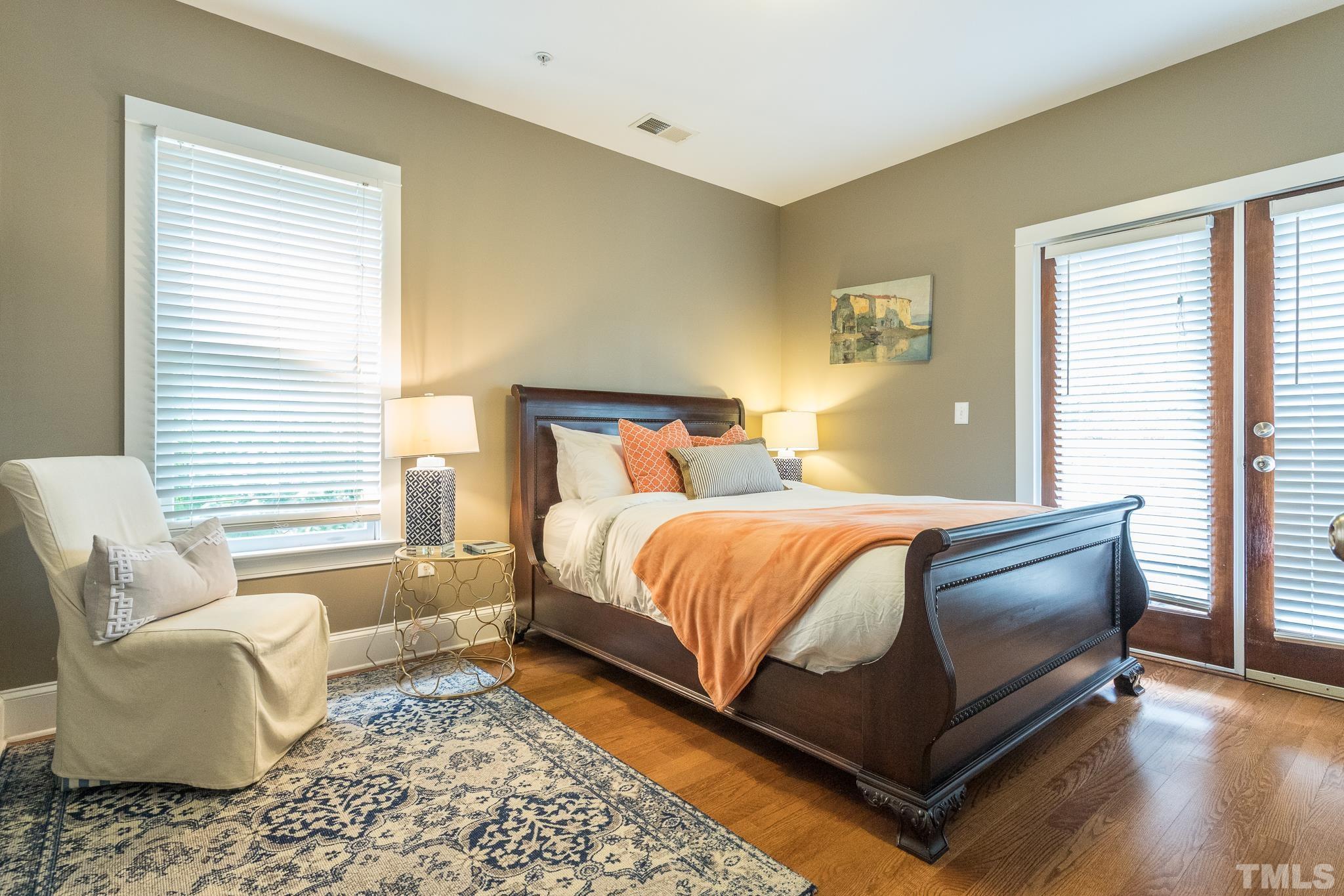 613 West Cabarrus Street, Unit 202 Raleigh, NC 27603 - Photo 11 of 25 a bedroom with a bed and wooden floor