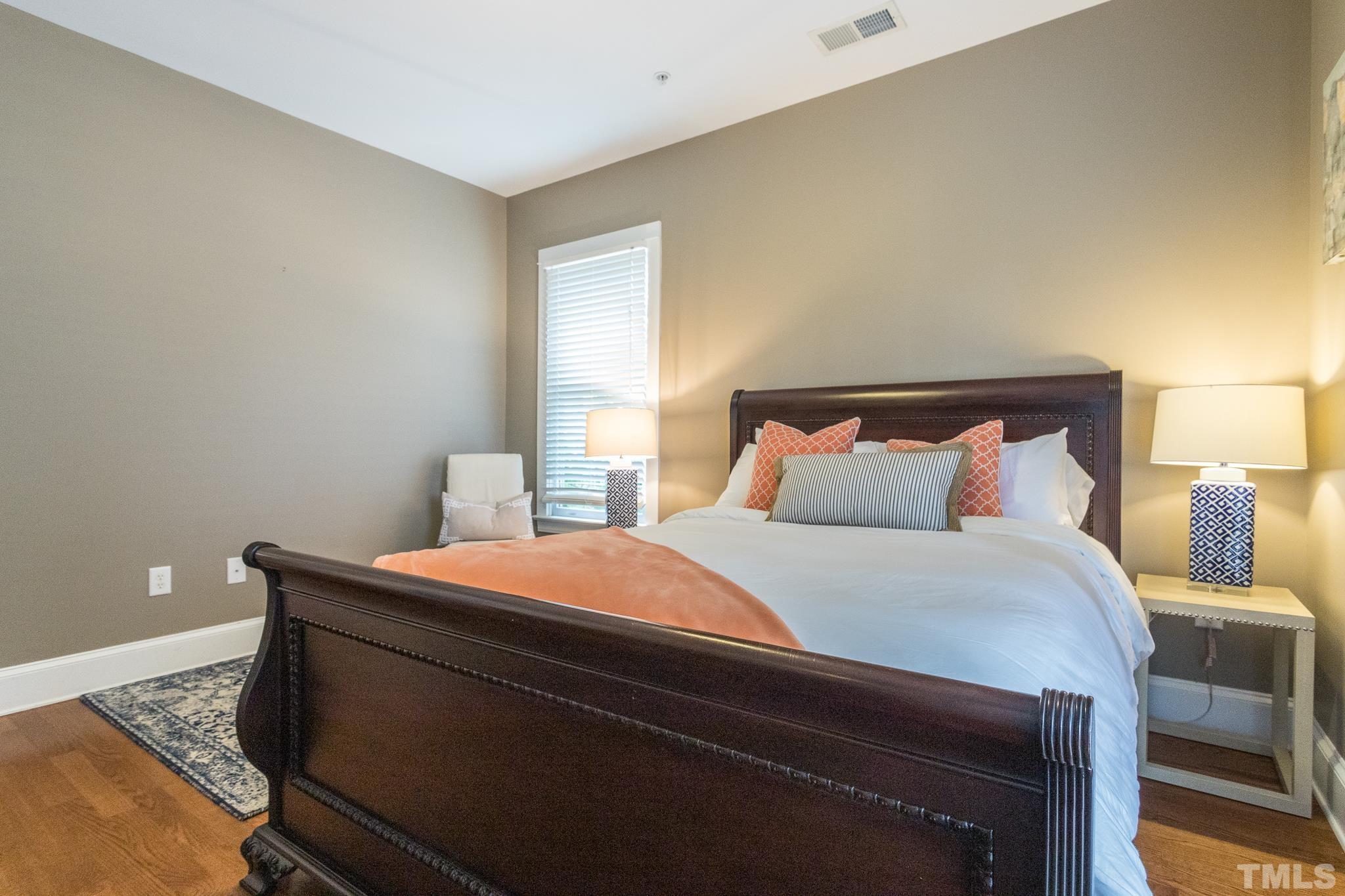 613 West Cabarrus Street, Unit 202 Raleigh, NC 27603 - Photo 12 of 25 a bedroom with a bed and a lamp