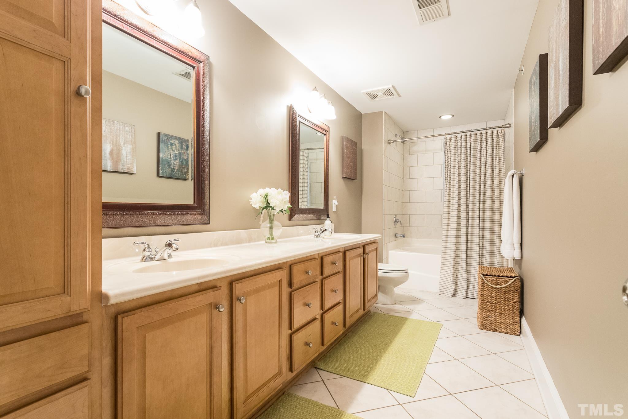 613 West Cabarrus Street, Unit 202 Raleigh, NC 27603 - Photo 19 of 25 a spacious bathroom with a double vanity sink mirror and a bathtub