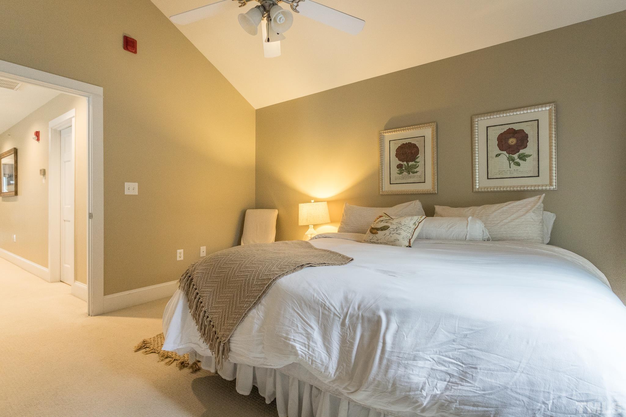 613 West Cabarrus Street, Unit 202 Raleigh, NC 27603 - Photo 22 of 25 a bedroom with a bed and a chandelier