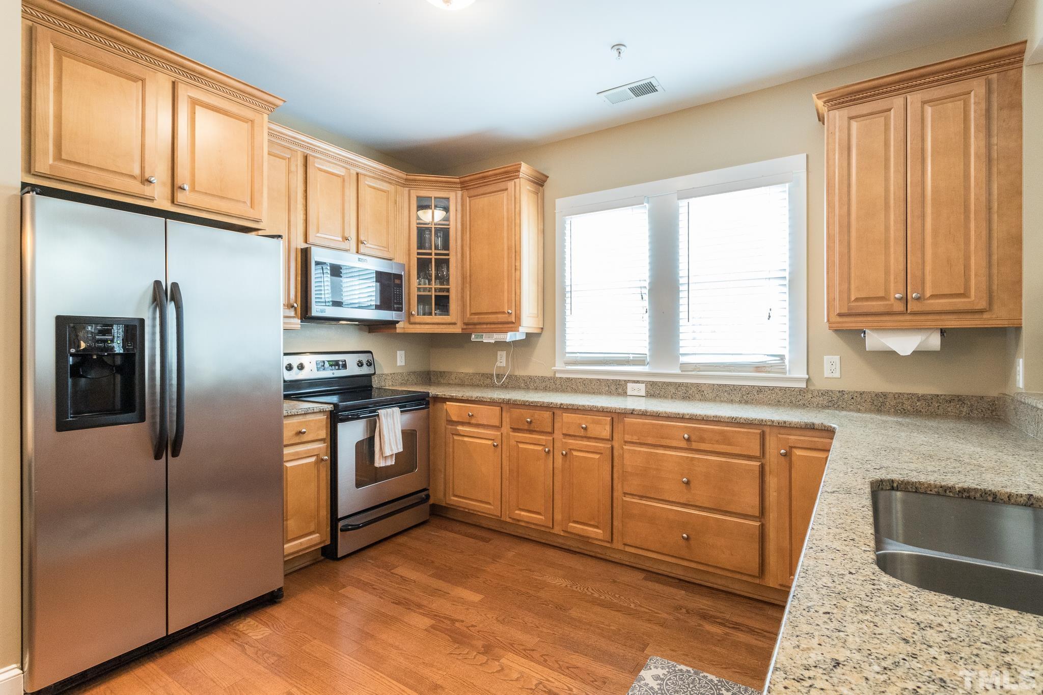 613 West Cabarrus Street, Unit 202 Raleigh, NC 27603 - Photo 3 of 25 a kitchen with stainless steel appliances granite countertop a refrigerator sink and cabinets