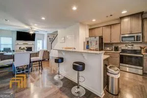 a kitchen with stainless steel appliances kitchen island granite countertop a refrigerator and a stove top oven