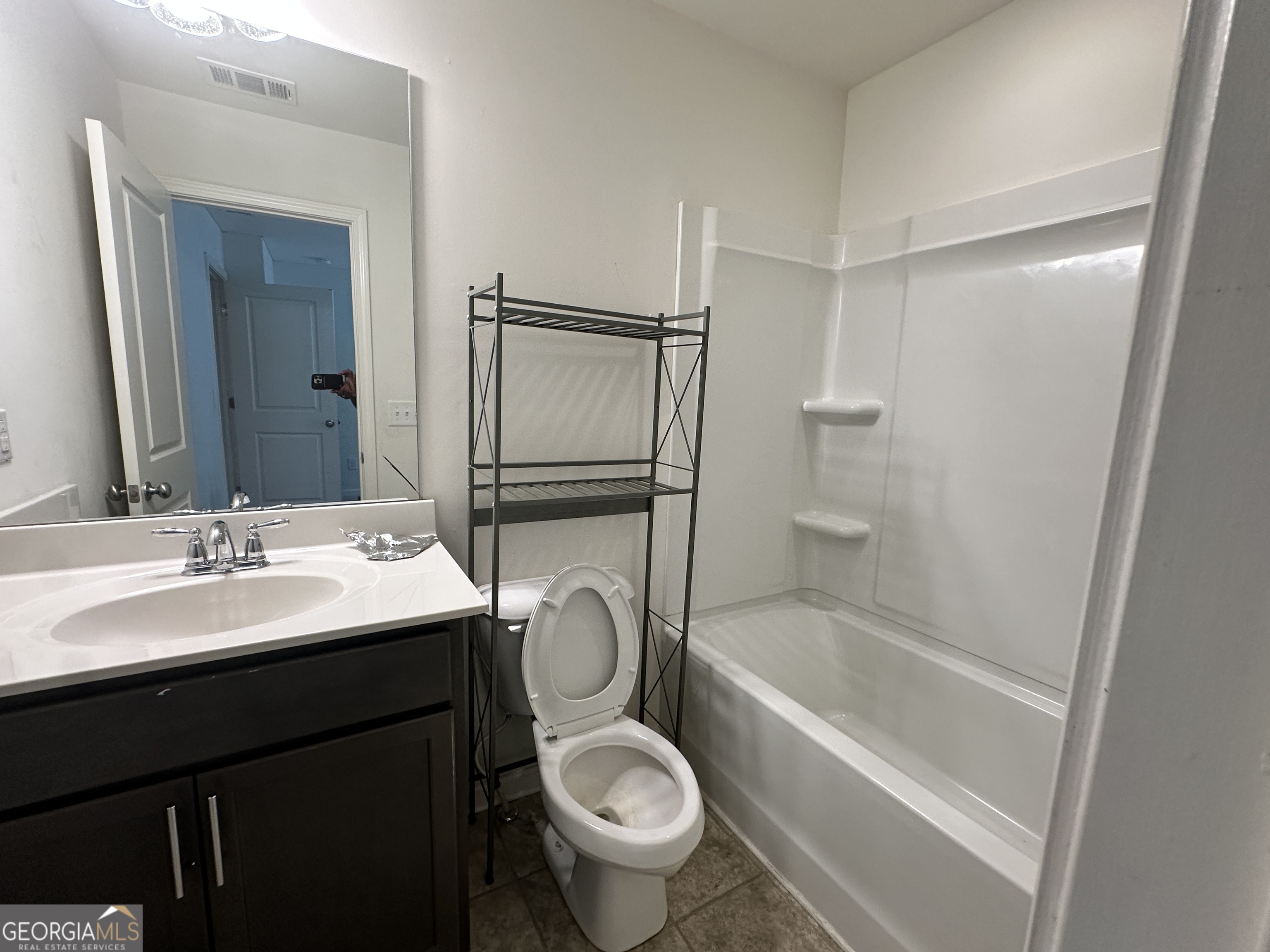 882 Ambient Way Atlanta, GA 30331 - Photo 10 of 61 a bathroom with a granite countertop sink toilet mirror and shower