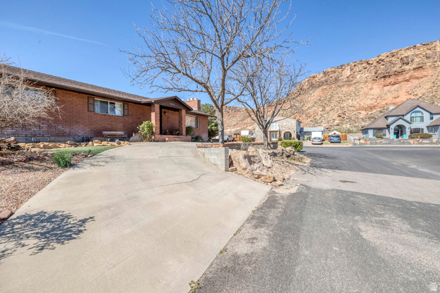 3334 Ute Road St. George, UT 84790 - Photo 40 of 40 View of front facade with a chimney, a residential view, brick siding, and a mountain view