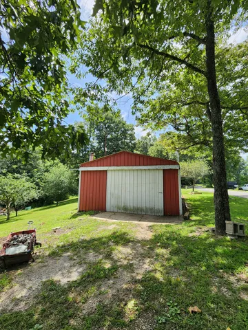 a view of a yard with barn house in the background
