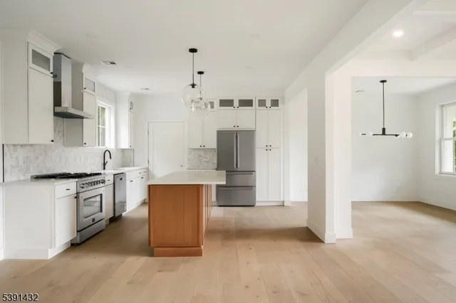 a large kitchen with stainless steel appliances granite countertop a stove and a refrigerator