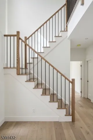 a view of staircase with lots of white walls and a black gate