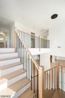 a view of staircase with lots of frames on wall and a large window