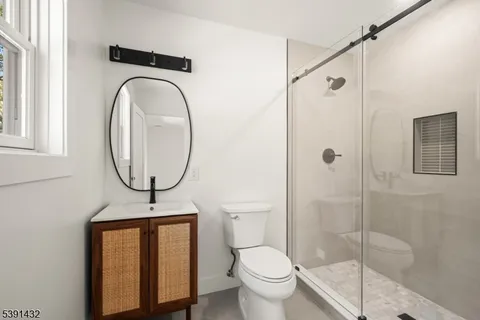 a bathroom with a toilet a sink and a mirror