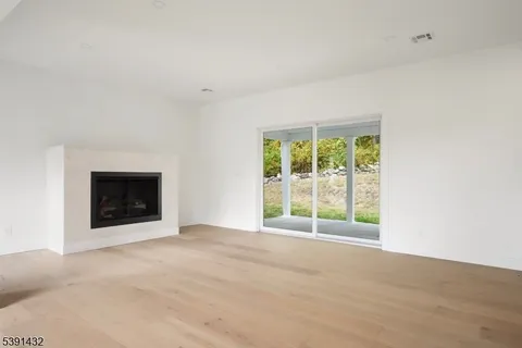 a view of an empty room with a window and a fireplace
