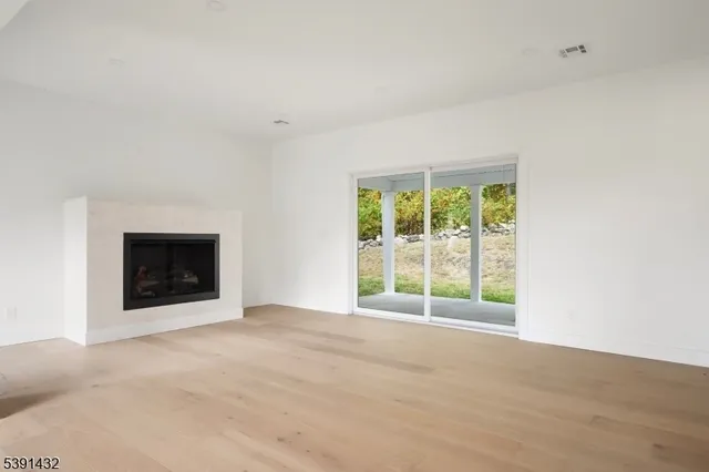 a view of an empty room with a window and a fireplace