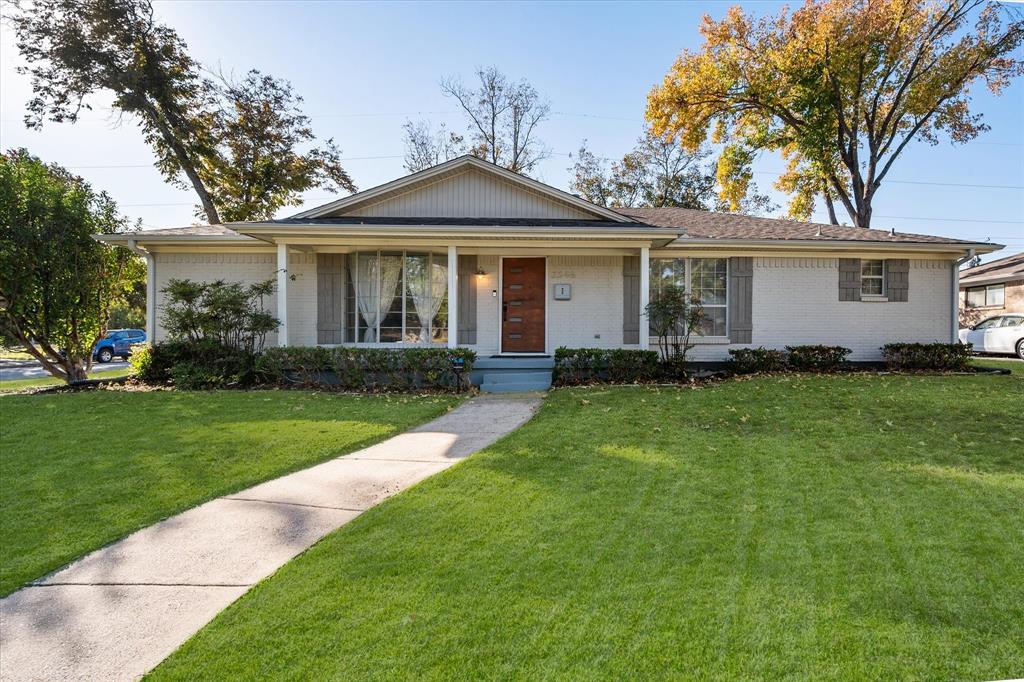 a front view of a house with a yard and trees
