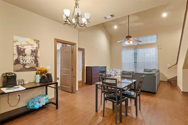 a view of a dining room with furniture a chandelier and wooden floor