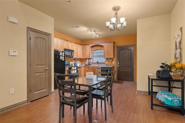 a view of a dining room with furniture a chandelier and wooden floor
