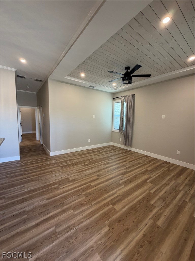 11595 Tomato Road Naples, FL 34114 - Photo 11 of 15 an empty room with wooden floor and a ceiling fan