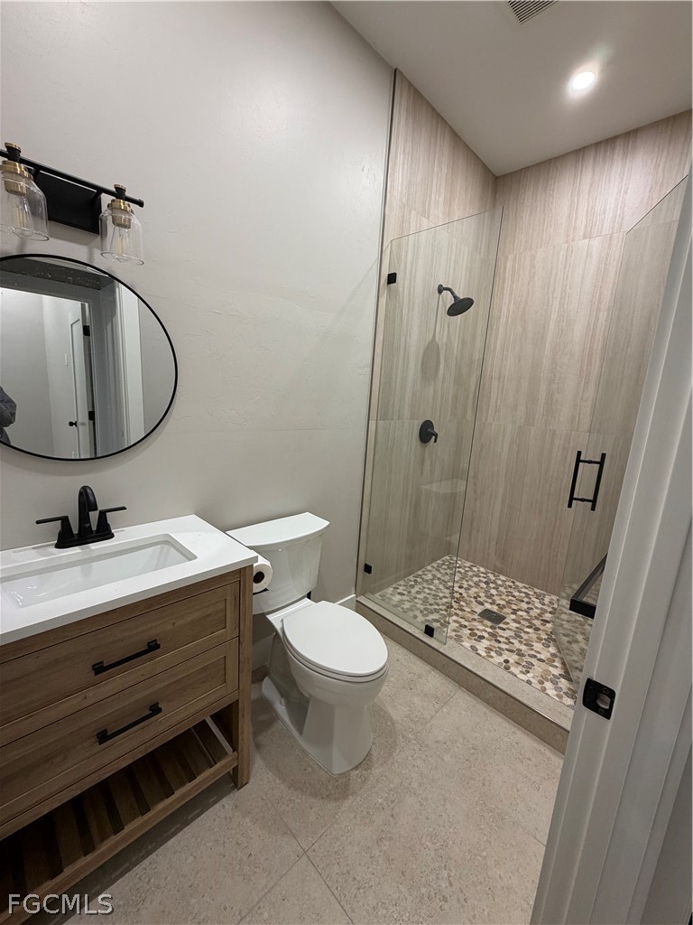 11595 Tomato Road Naples, FL 34114 - Photo 12 of 15 a bathroom with a sink a toilet a shower and a mirror